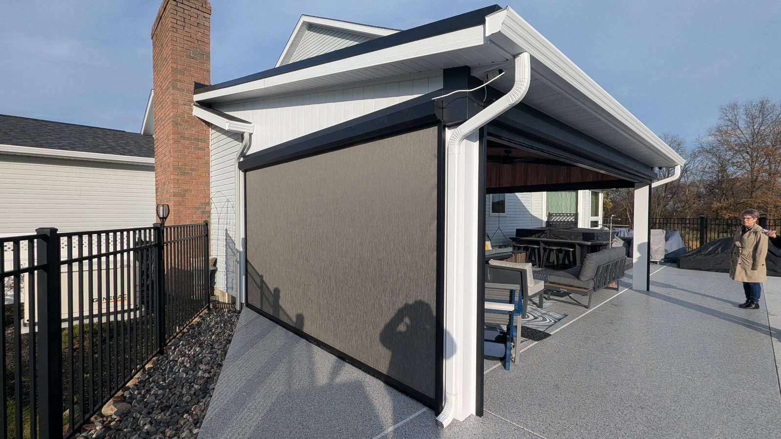 White soffit, fascia and gutter trim a covered patio fitted with a dark retractable screen.