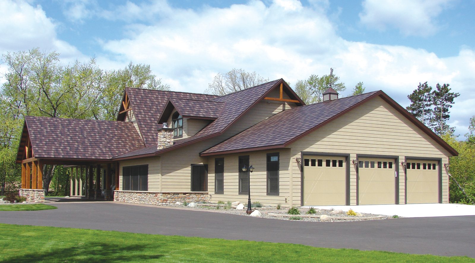 Brown steel shake roofing runs across a tan craftsman home with a timber entry and three-car garage.