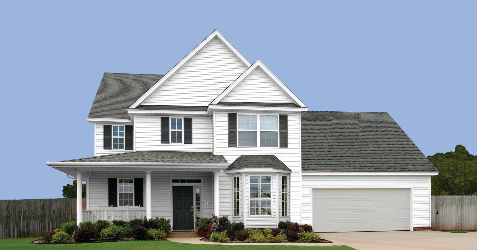 White lap siding covers a two-story home with a bay window, front porch and attached garage.